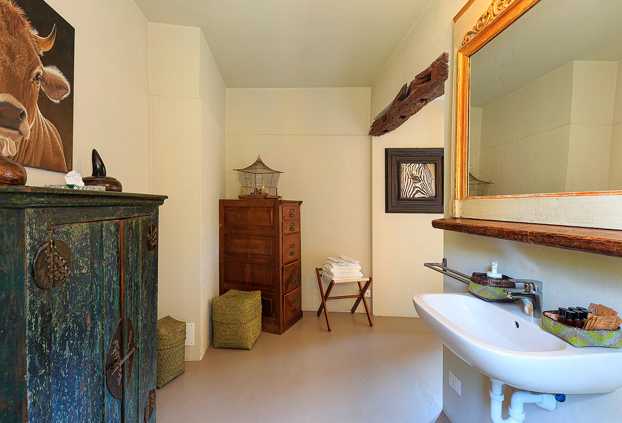 villa-wirnica-la-canonica-suite-bathroom-rustic-painted-cabinet La Canonica Suite bathroom with modern sink and rustic painted cabinet, showcasing unique design blend.