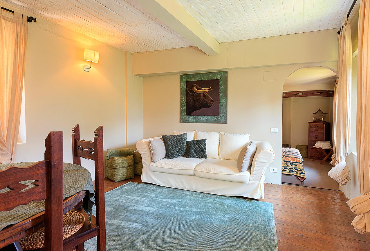 villa-wirnica-la-canonica-suite-living-room-bull-artwork-sofa La Canonica Suite living room with cozy modern sofa and unique bull artwork, ideal for family accommodation.