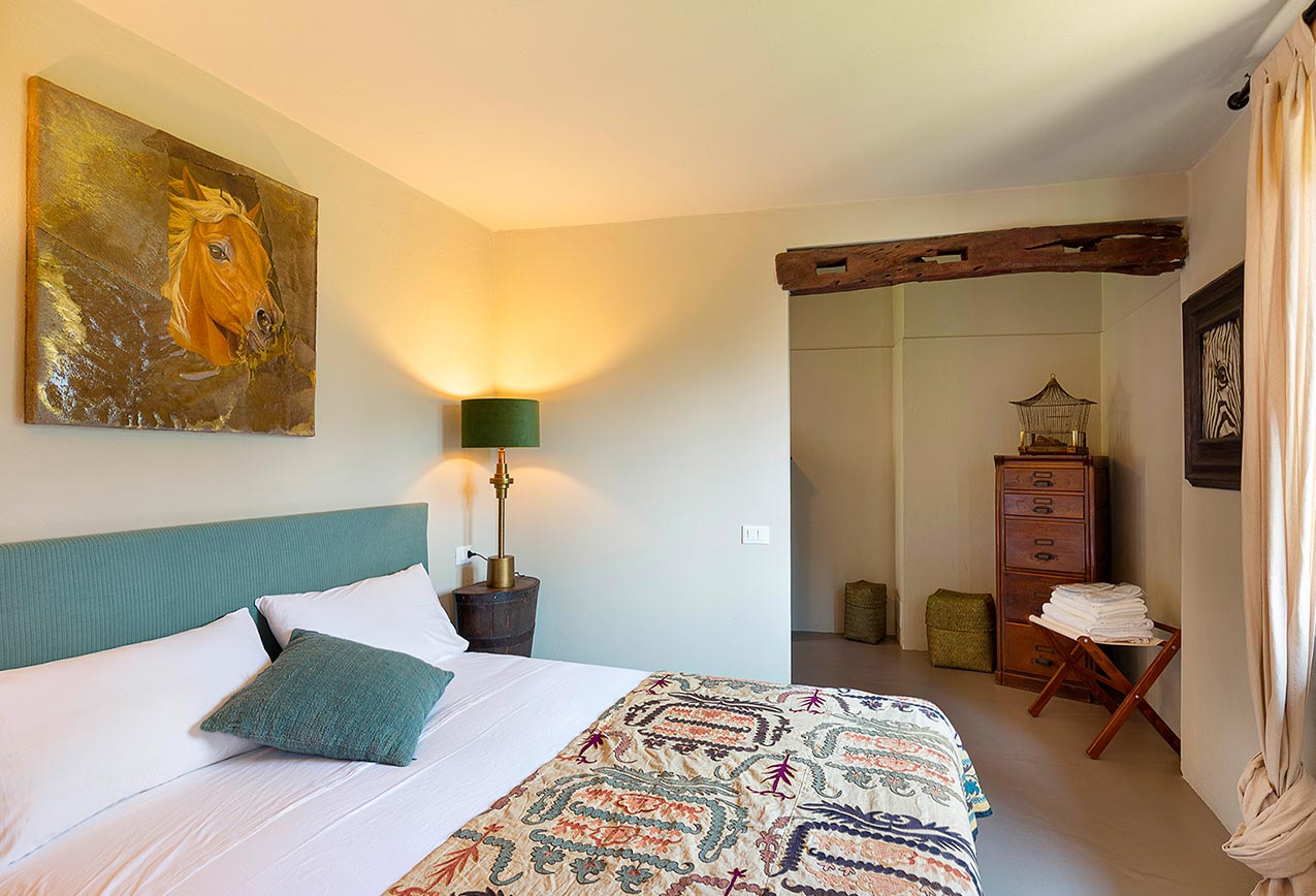 villa-wirnica-la-canonica-suite-modern-bedroom-horse-art La Canonica Suite modern bedroom featuring a unique horse painting and cozy, rustic modern design.