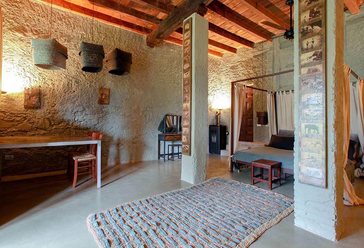 villa-wirnica-la-cappella-suite-wide-view-stone-beams-interior Wide view of La Cappella Suite's unique interior, showcasing rustic stone walls, exposed wooden beams, and spacious living area.